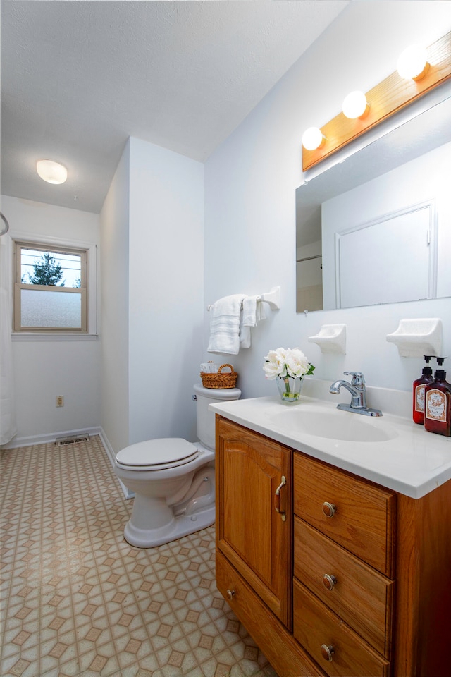 bathroom featuring vanity, tile patterned floors, and toilet