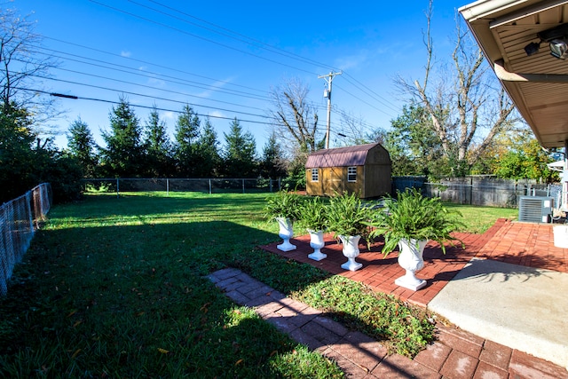 view of yard with a shed, central AC, and a patio