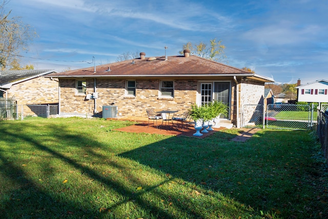 rear view of house with a patio, cooling unit, and a yard