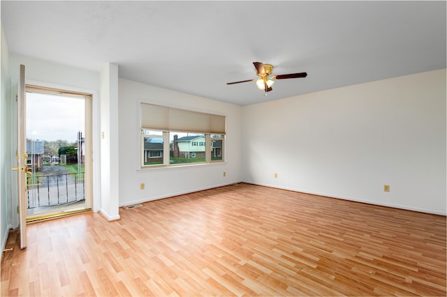 empty room with ceiling fan and light hardwood / wood-style flooring