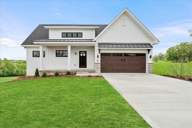 modern farmhouse style home with concrete driveway, board and batten siding, a front lawn, roof with shingles, and a standing seam roof