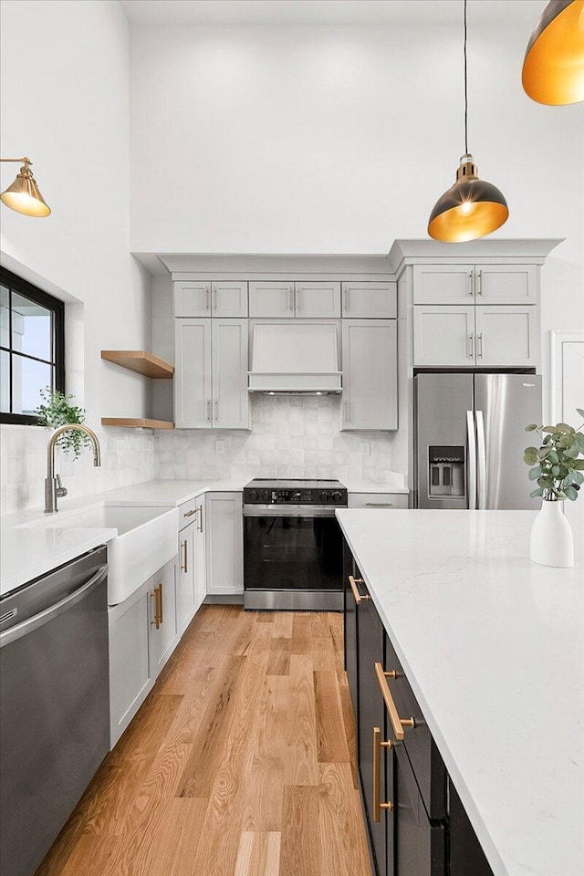 kitchen with open shelves, light countertops, appliances with stainless steel finishes, and custom range hood
