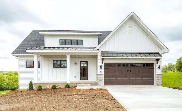 modern inspired farmhouse with a shingled roof, board and batten siding, driveway, and a standing seam roof