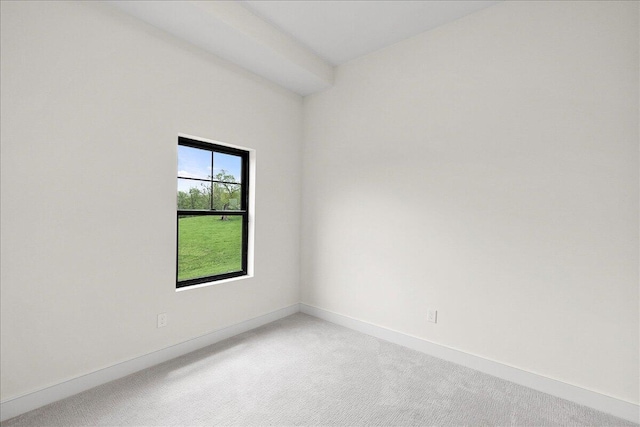 unfurnished room with light colored carpet and baseboards