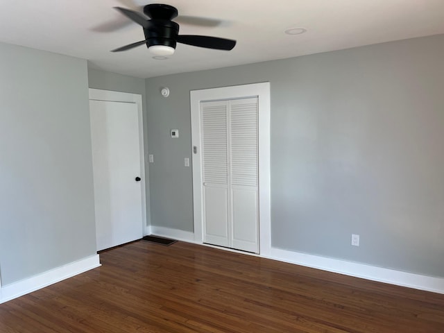 unfurnished bedroom featuring a closet, ceiling fan, and dark hardwood / wood-style flooring