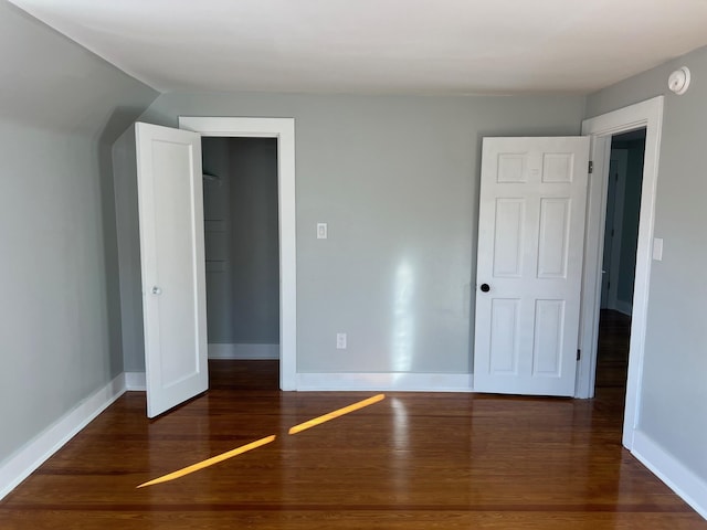 unfurnished bedroom with dark wood-type flooring