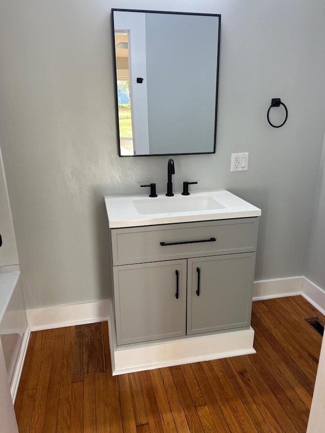 bathroom featuring hardwood / wood-style floors, vanity, and a tub to relax in