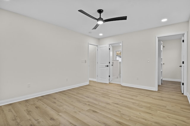 unfurnished bedroom featuring ceiling fan, a walk in closet, ensuite bathroom, and light hardwood / wood-style flooring