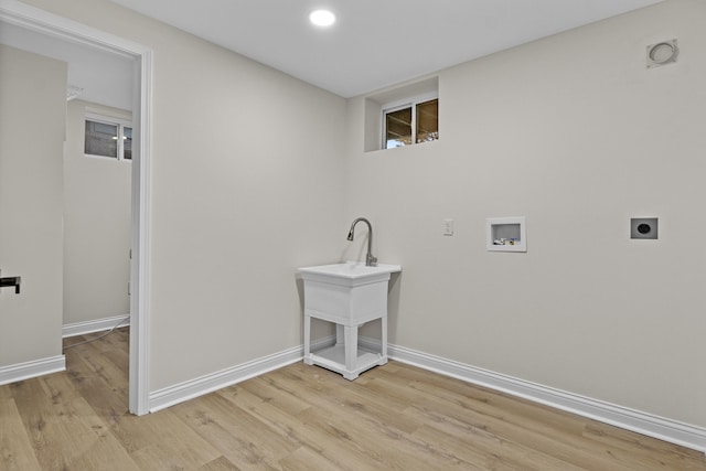 clothes washing area with hookup for a washing machine, hookup for an electric dryer, and light hardwood / wood-style flooring