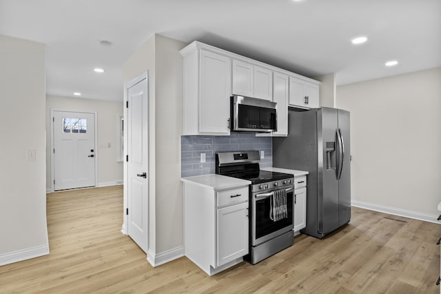 kitchen with white cabinetry, tasteful backsplash, light hardwood / wood-style floors, and appliances with stainless steel finishes