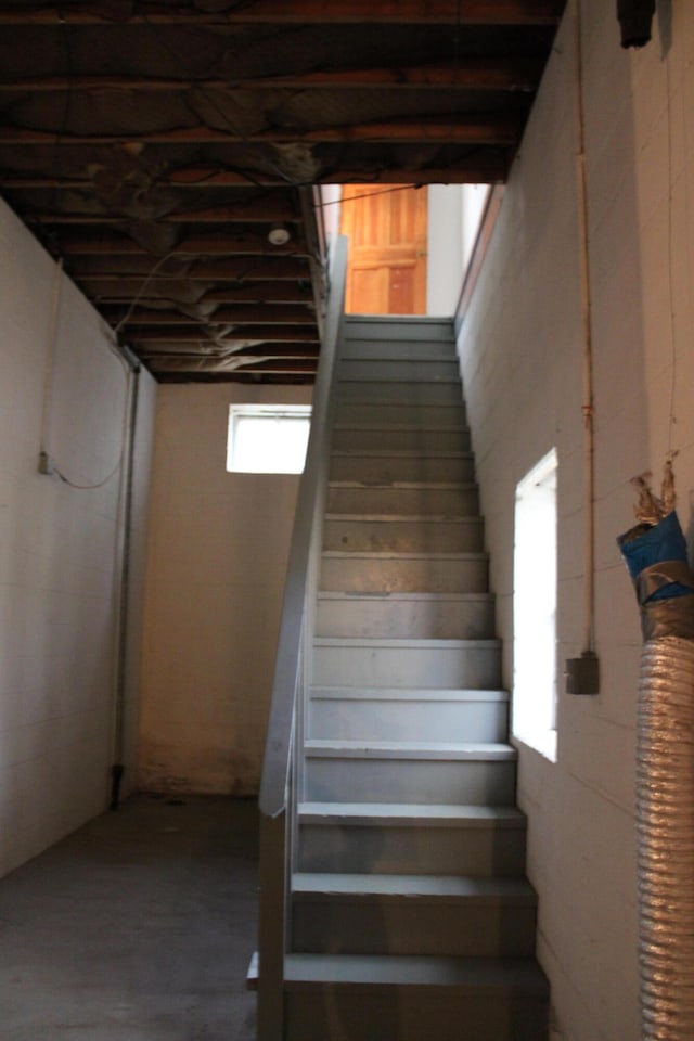 stairway featuring concrete flooring and plenty of natural light