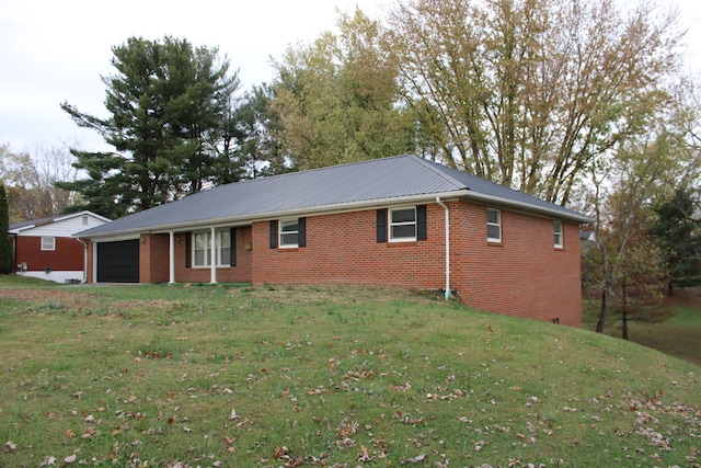 view of side of home featuring a garage and a lawn