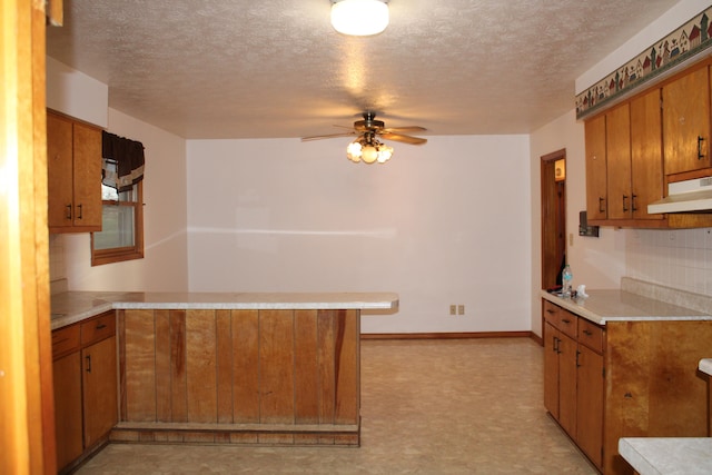 kitchen featuring kitchen peninsula, a textured ceiling, and ceiling fan