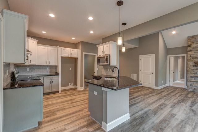 kitchen featuring white cabinetry, pendant lighting, range, and light hardwood / wood-style floors