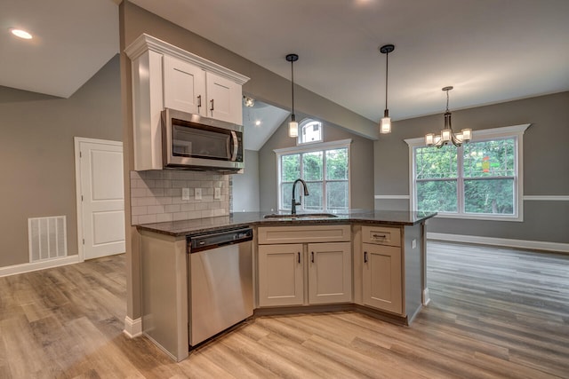 kitchen with light wood-type flooring, appliances with stainless steel finishes, and white cabinets