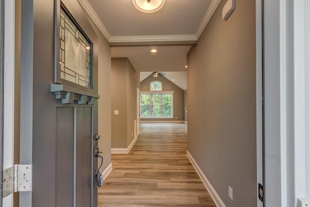 hall featuring ornamental molding, light wood-type flooring, and vaulted ceiling