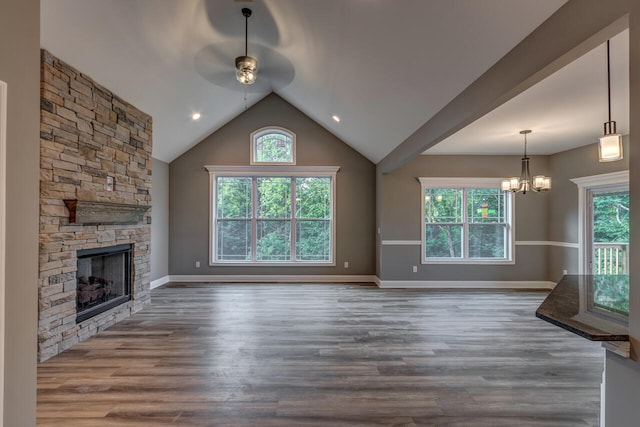 unfurnished living room with hardwood / wood-style floors, a wealth of natural light, lofted ceiling, and a fireplace