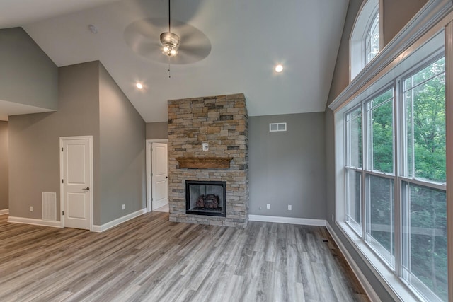 unfurnished living room featuring high vaulted ceiling, ceiling fan, light hardwood / wood-style floors, and a fireplace