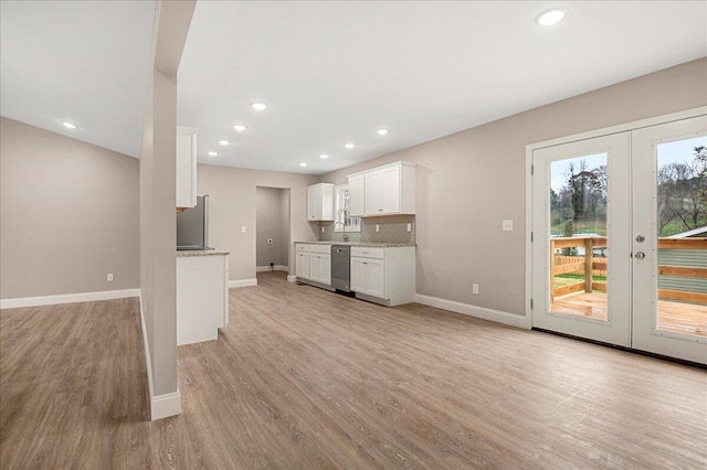 kitchen with french doors, appliances with stainless steel finishes, sink, light hardwood / wood-style flooring, and white cabinetry