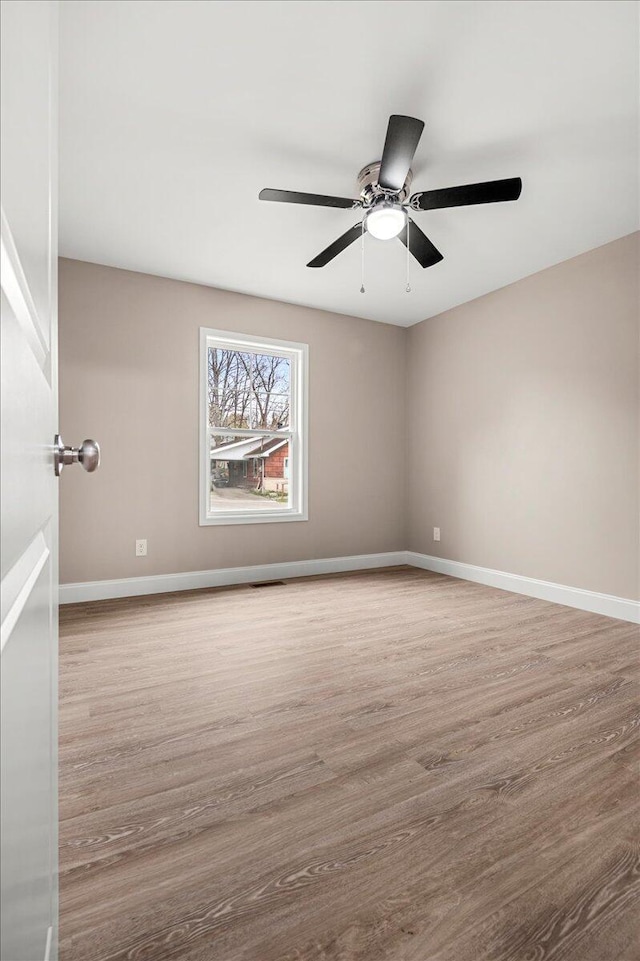 empty room with ceiling fan and light hardwood / wood-style floors