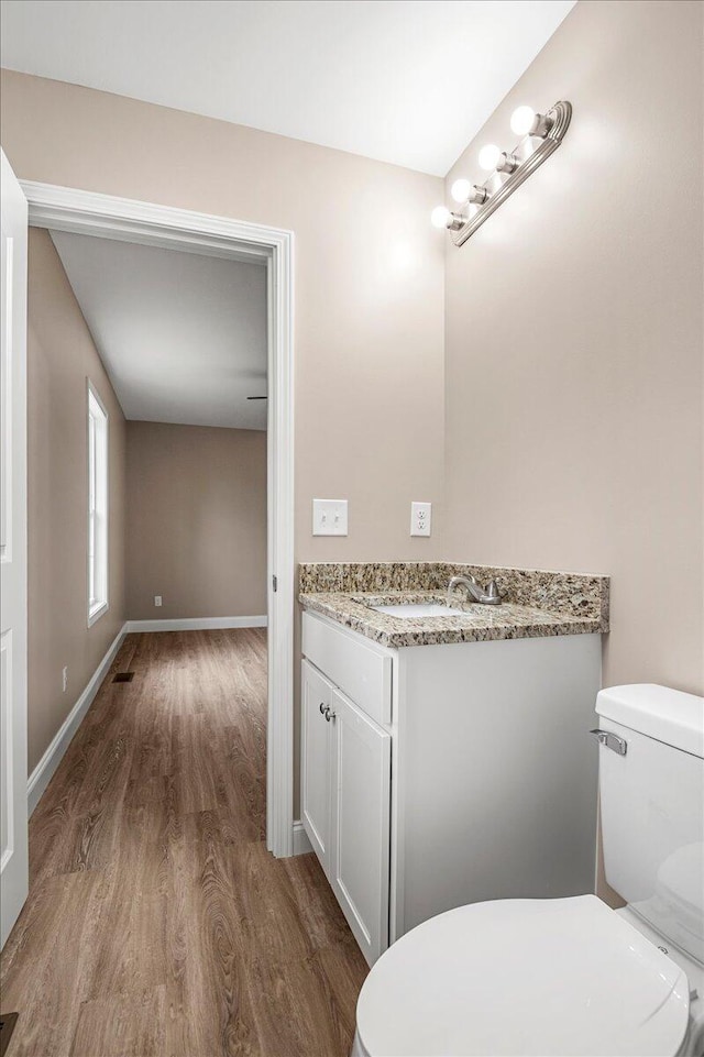 bathroom featuring hardwood / wood-style floors, vanity, and toilet