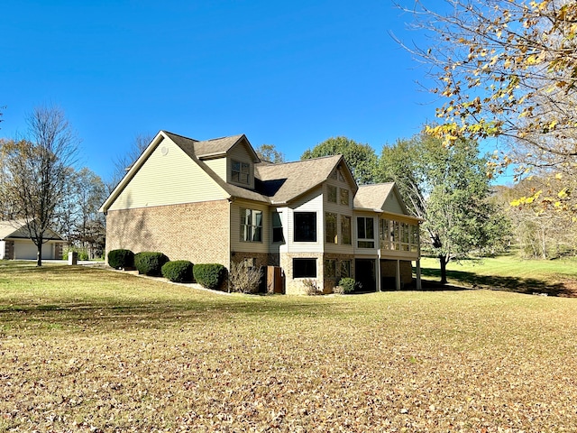 view of home's exterior featuring a lawn and a sunroom