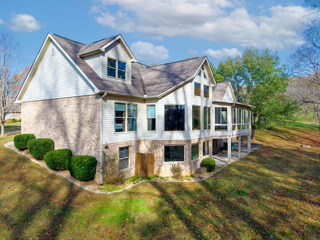 rear view of property featuring a patio and a lawn