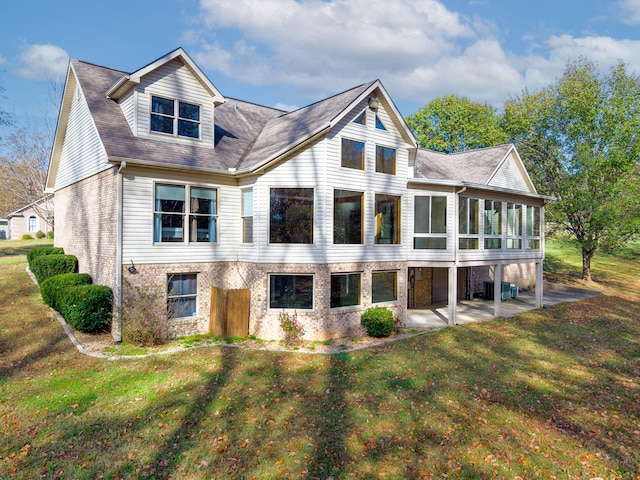 view of front facade with a patio, central AC unit, a front lawn, and a sunroom