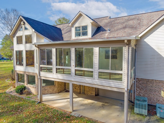 rear view of property featuring a sunroom, cooling unit, and a patio