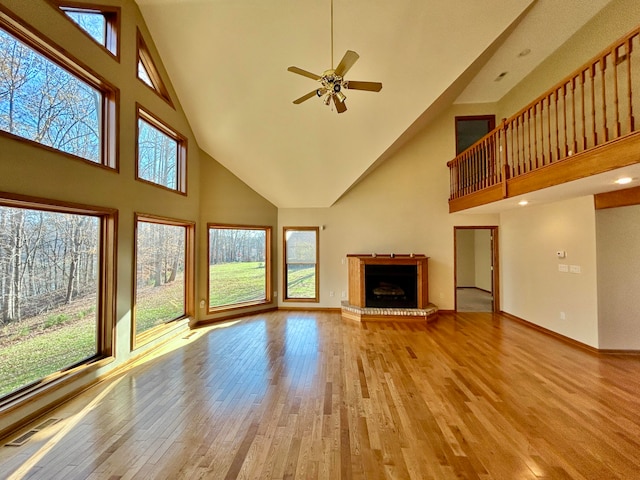 unfurnished living room with light hardwood / wood-style flooring, high vaulted ceiling, and ceiling fan