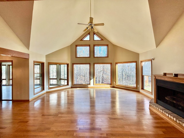 unfurnished living room featuring a fireplace, light wood-type flooring, plenty of natural light, and ceiling fan