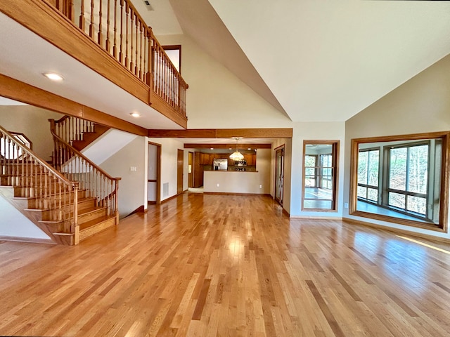 unfurnished living room featuring hardwood / wood-style flooring and high vaulted ceiling