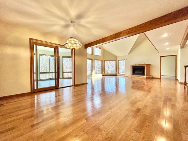 unfurnished living room featuring vaulted ceiling with beams, light hardwood / wood-style flooring, and an inviting chandelier