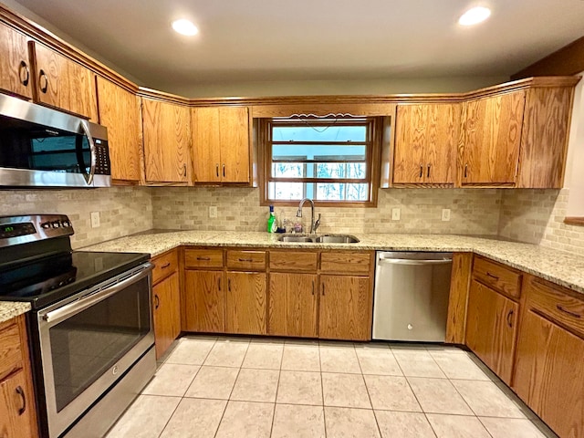 kitchen with backsplash, sink, light tile patterned flooring, and stainless steel appliances