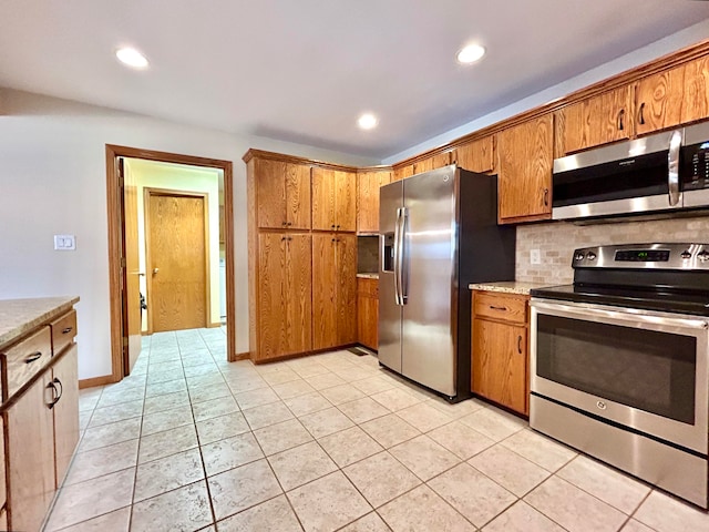 kitchen featuring decorative backsplash, light tile patterned floors, and stainless steel appliances