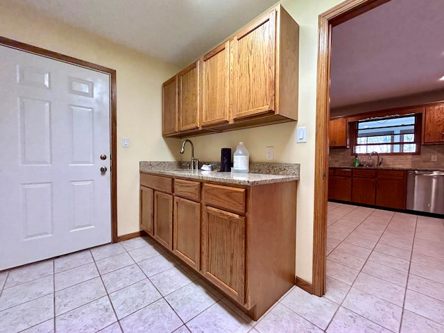 kitchen featuring sink, light tile patterned flooring, and stainless steel dishwasher