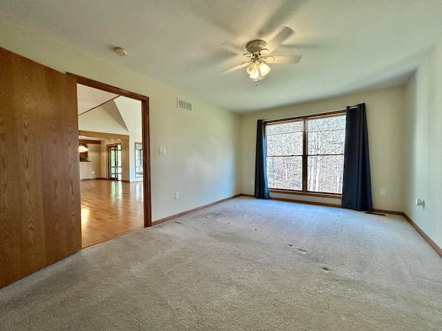 carpeted spare room featuring ceiling fan