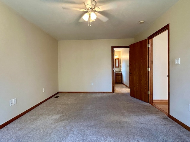 carpeted spare room featuring ceiling fan