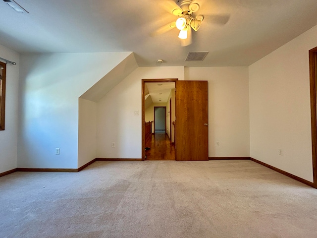 additional living space with ceiling fan and carpet