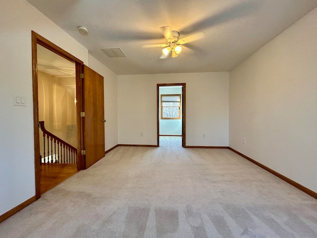 carpeted spare room featuring ceiling fan