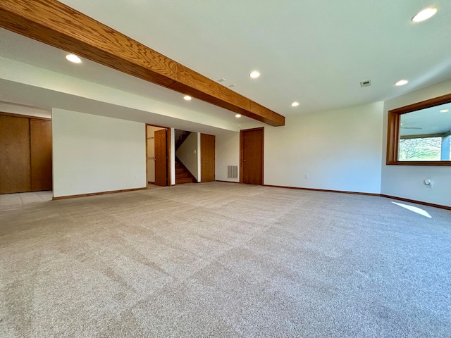 carpeted spare room with beamed ceiling