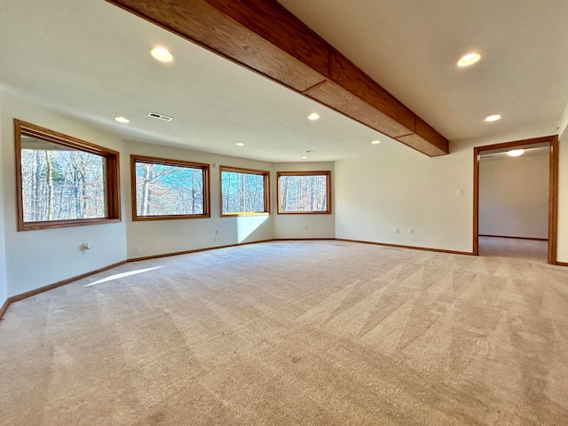 carpeted spare room with beamed ceiling