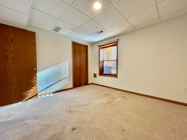 carpeted spare room with a paneled ceiling