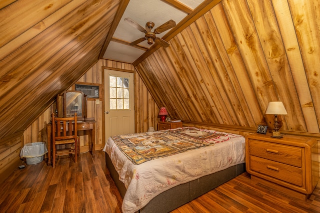 bedroom with dark wood-type flooring, ceiling fan, wooden walls, and lofted ceiling