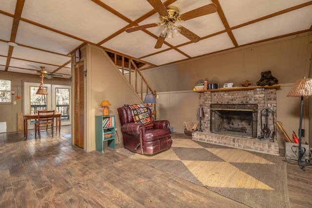 living room with coffered ceiling, hardwood / wood-style flooring, ceiling fan, and a fireplace