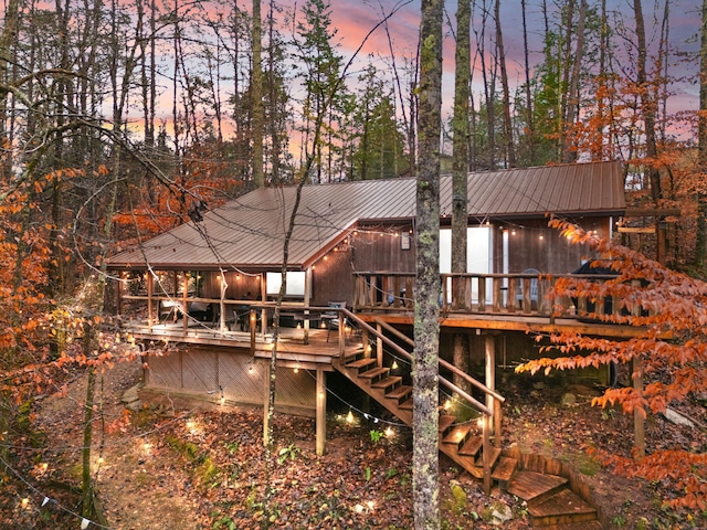 back house at dusk featuring a deck