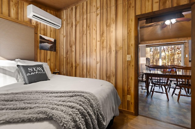 bedroom featuring an AC wall unit, dark wood-type flooring, and wood walls