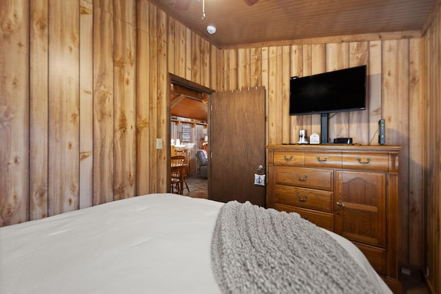 bedroom featuring wooden walls