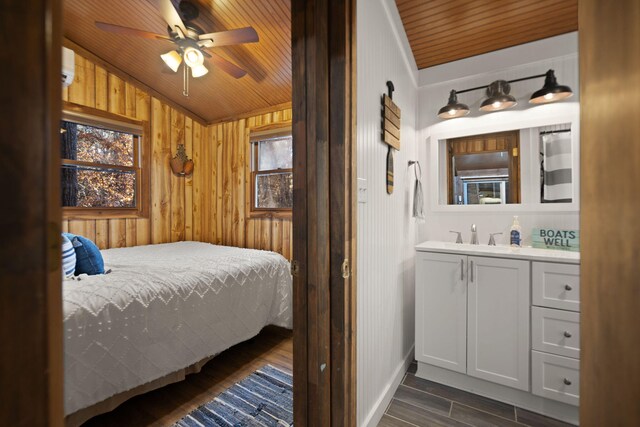 bedroom featuring wood walls, ceiling fan, wood ceiling, and vaulted ceiling