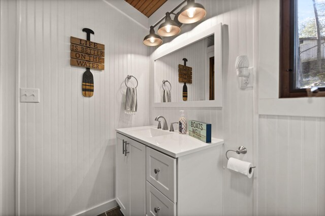 bathroom featuring vanity and wood walls